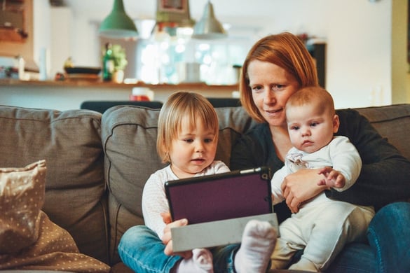 Photo of mom with children looking at tablet by Alexander Dummer from Unsplash