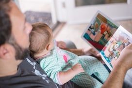 Photo of father reading to child on lap by Picsea from Unsplash