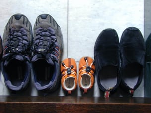 Photo of three pairs of shoes at the door.